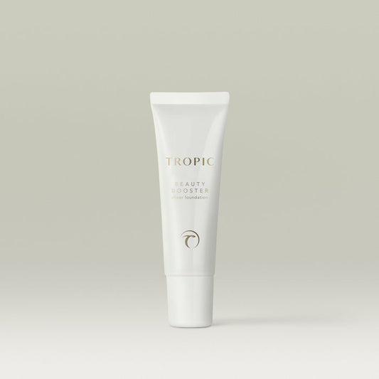 A white tube of Tropic Beauty Booster sheer foundation standing upright against a soft neutral background.
