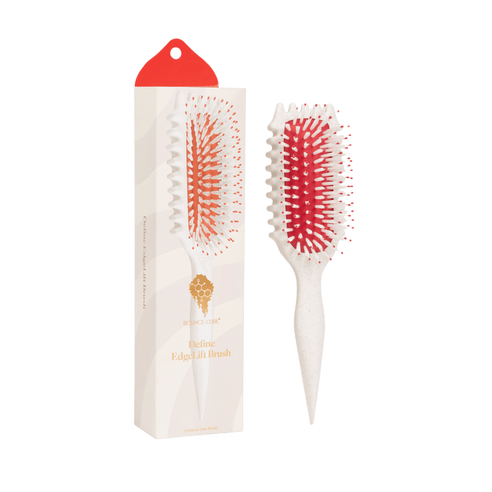 Hairbrush with red bristles and white handle next to its packaging on a green background