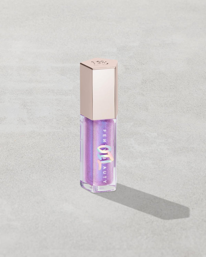 Gloss Bomb Oil Luminizing Oil and  Gloss in shade Miss Jellyfish product against a concrete background.