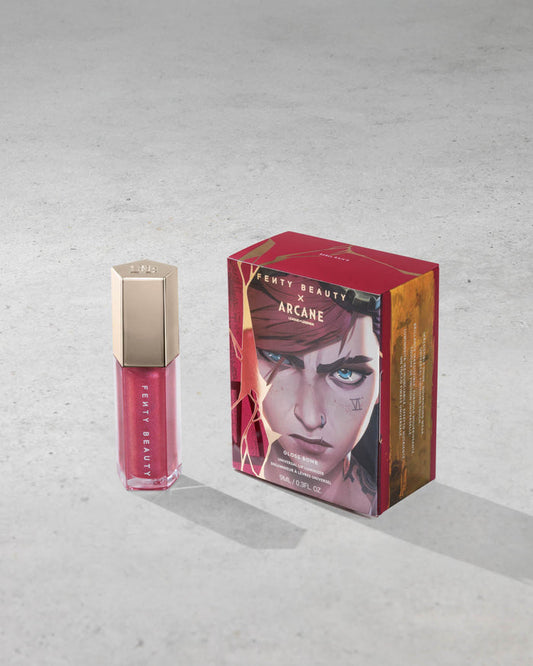 Product shot of Fenty Beauty Gloss Bomb Universal Lip Luminizer and packaging in limited edition Arcane collection shade Rebel Raiser.