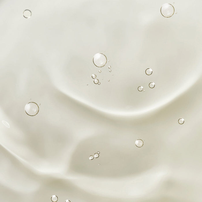 Close-up of clear cuticle oil texture with small air bubbles suspended in a smooth, glossy surface.