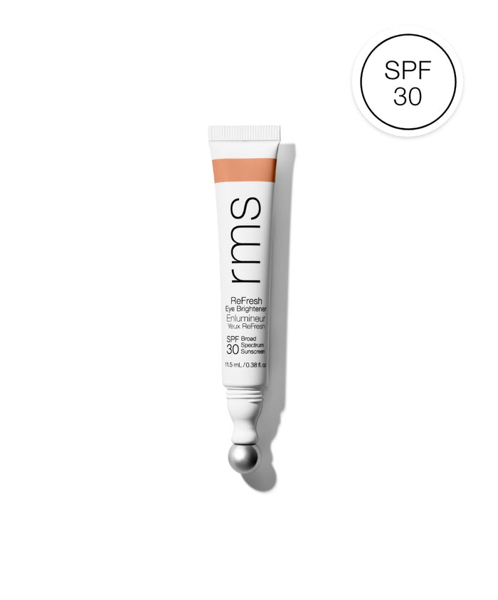 Tube of ReFresh Eye Brightener Broad Spectrum SPF 30 + Correcting Tint by RMS Beauty with a soft peach tint and built-in metal applicator ball, highlighting clean beauty and skincare infused makeup.