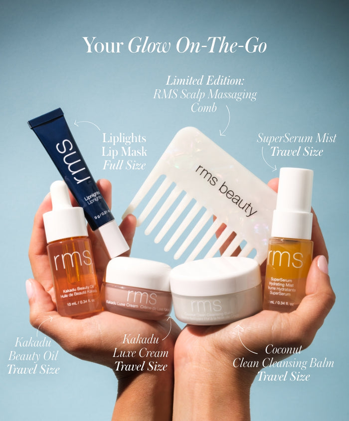 Hands holding The Travel Skincare Set featuring travel-size skincare products including Kakadu Beauty Oil, Kakadu Luxe Cream, Coconut Clean Cleansing Balm, SuperSerum Mist, a full-size Liplights Lip Mask, and a limited edition RMS Scalp Massaging Comb.