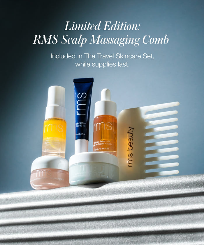 A collection of skincare products including bottles, jars, a blue tube, and a limited edition RMS scalp massaging comb, all part of The Travel Skincare Set with clean, natural ingredients.