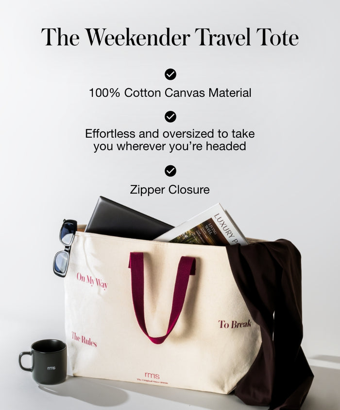 The Weekender Travel Tote made from 100% cotton canvas, featuring a zipper closure, oversized design, and burgundy handles, styled with sunglasses, laptop, and coffee cup nearby.