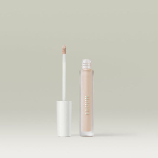 A frosted tube of Tropic Undercover concealer in shade 1 with a white cap, shown open beside its doe-foot applicator coated in product, against a soft neutral background.